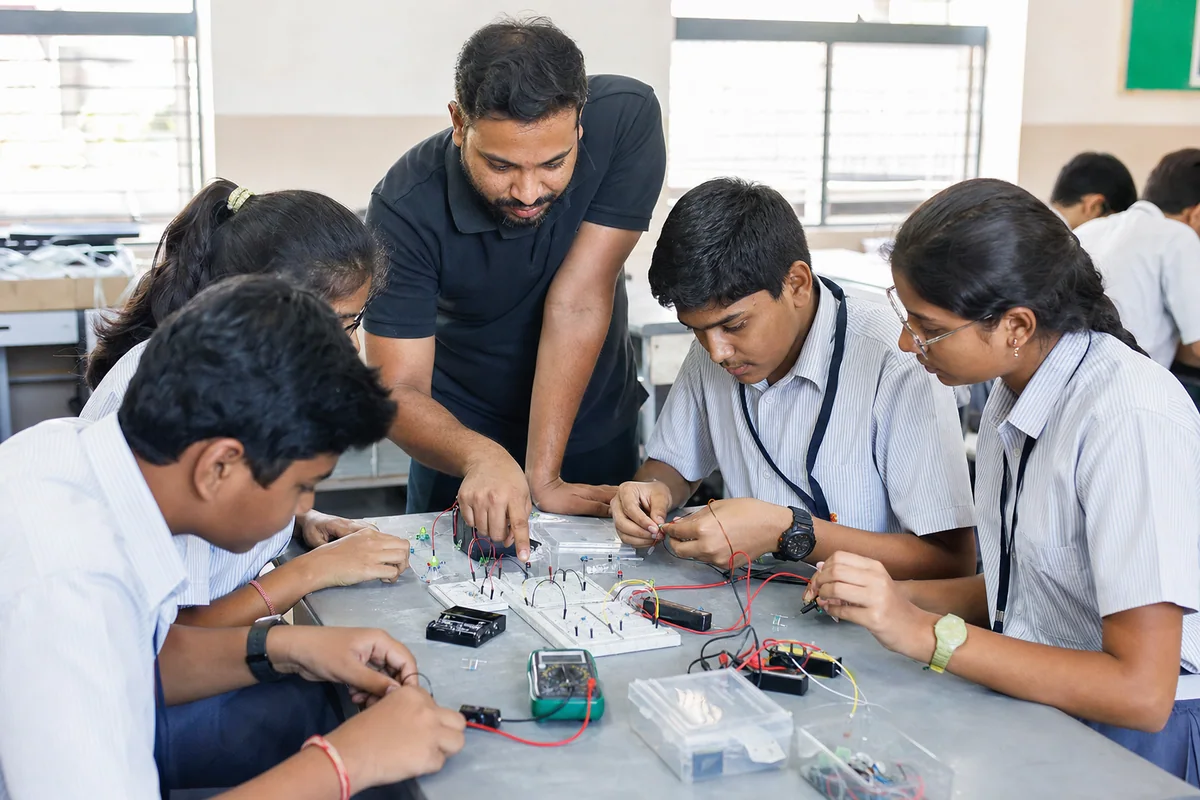 Students building an electronic circuit together with instructor guidance